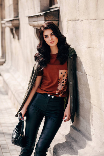 fashion outdoor photo of beautiful woman with dark hair in elegant clothes posing in the spring street - Zdjęcie, obraz