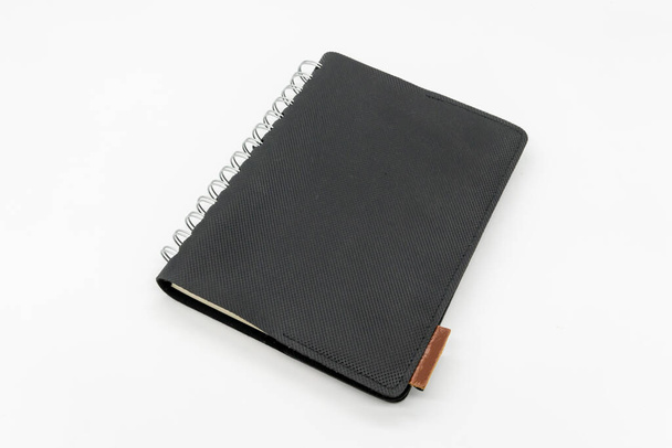 Zwart leren zakboekje of schetsboek geïsoleerd op witte achtergrond. - Foto, afbeelding