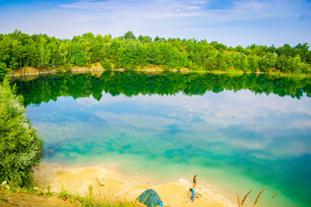 Dos turistas y una chica en el lago. Paisaje. Ucrania. En el fondo del cielo azul
. - Foto, Imagen