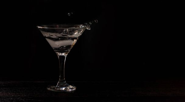 alcohol coctail glass on a black background. Splash of cocktail. banner for designers - Foto, imagen
