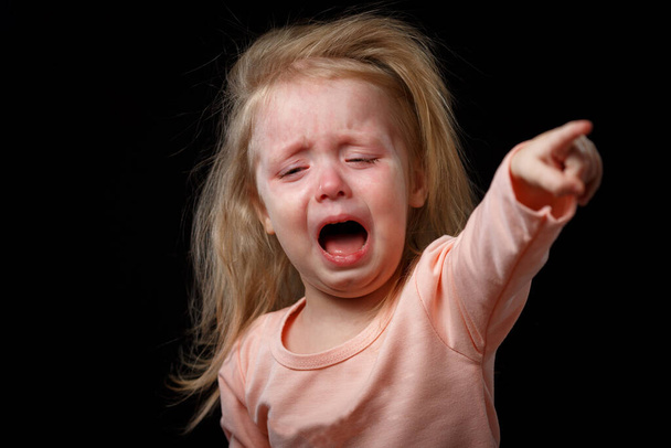 Бідна дівчинка плаче істерично, наганяючи пальцем на свого буревісника. Її волосся зачесане і вона не може заспокоїтися. - Фото, зображення