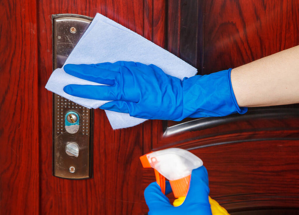 Kobieta dezynfekuje klamkę w domu. kwarantanna dla koronawirusów. ręce zbliżenie - Zdjęcie, obraz