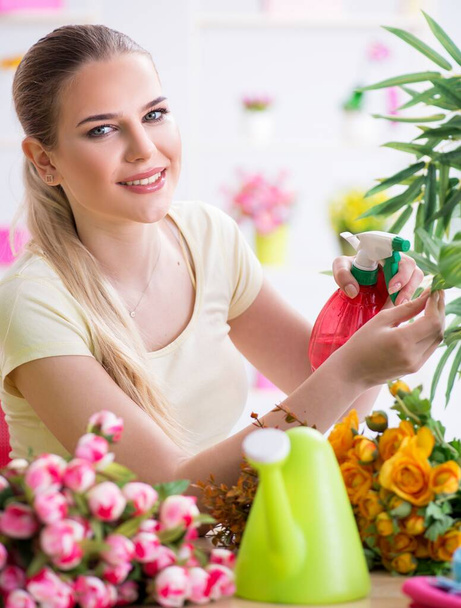 Fiatal nő öntözés növények kertjében - Fotó, kép