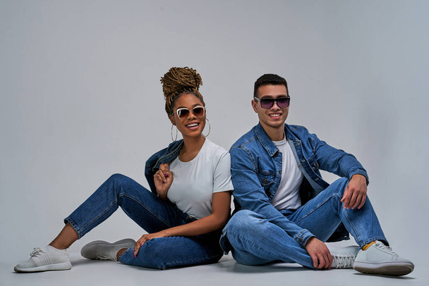 Woman in earrings with bun of braids and man with smiles in sunglasses posing - Φωτογραφία, εικόνα