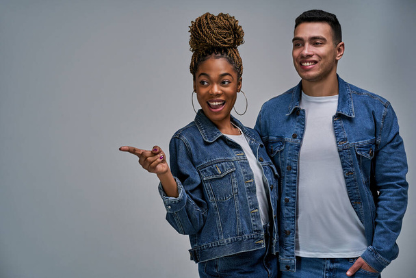 Woman and man with smiles in denim jackets pose stand close and cuddle - Фото, изображение