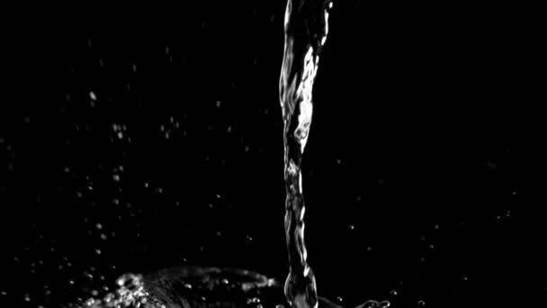 Szuper lassított mozgású öntés fröccsenő víz fekete háttér. Filmre véve nagy sebességű mozi kamera, 1000fps. - Felvétel, videó