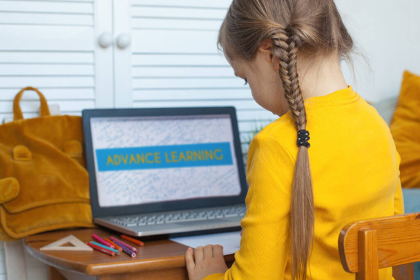 Мила дівчинка вчиться вдома. Дитина використовує ноутбук і картину
 - Фото, зображення
