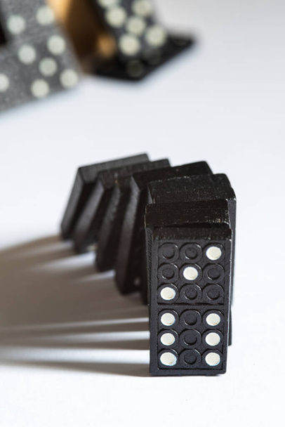 Bloques de dominó negro cayendo, aislados sobre fondo blanco
 - Foto, Imagen
