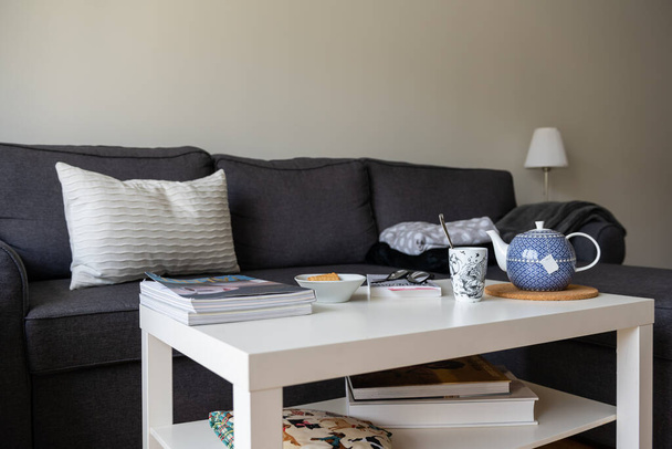 Cozy home setting, with pillows and blankets on couch, a warm cup of tea or coffee, and a good book. Nothing like home. Stock picture by Brian Holm Nielsen - Photo, Image