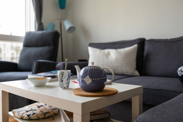 ソファの上の枕と毛布、暖かいお茶やコーヒー、そして良い本と居心地の良い家の設定。家とは違う。ブライアン・ホーム・ニールセンの写真 - 写真・画像