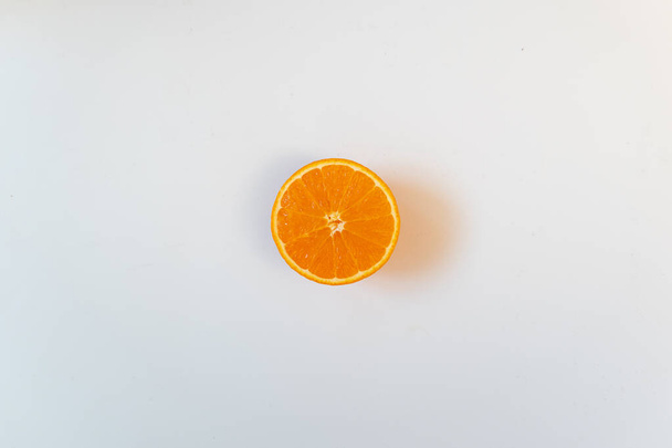 Geïsoleerd half oranje op een witte achtergrond. Vlakke lay, kopieerruimte, reclame - Foto, afbeelding