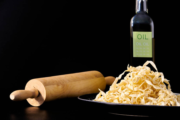 Tuore kotitekoinen italialainen tagliatelle, jossa puinen valssaustappi ja oliiviöljy
 - Valokuva, kuva