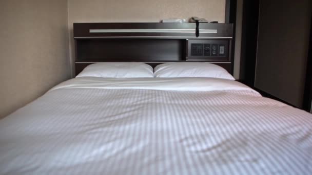 4K ein Doppelbett mit weißen Laken in einem Hotelzimmer-Dan - Filmmaterial, Video