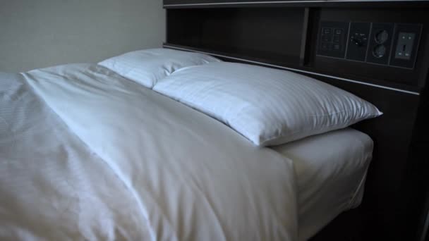 4K podwójne łóżko z białymi prześcieradłami w pokoju hotelowym-Dan - Materiał filmowy, wideo