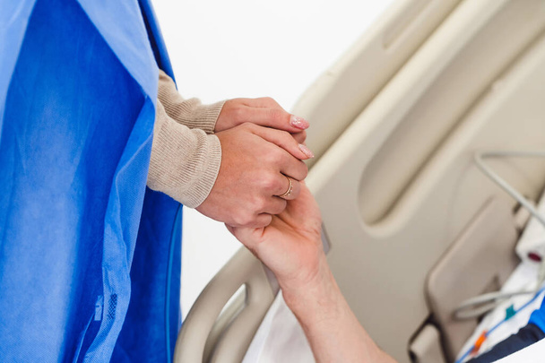 Holding patient hands in a hospital. Family help. Closeup. Support. - Foto, afbeelding