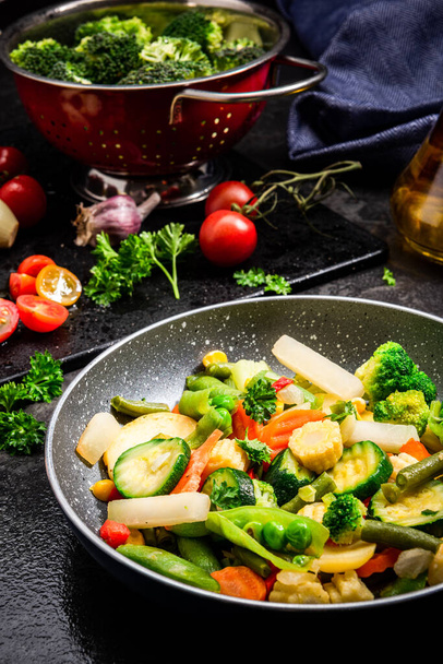 Ideas para un plato saludable en maceta. Remover las verduras fritas Mezclar en la sartén
. - Foto, Imagen