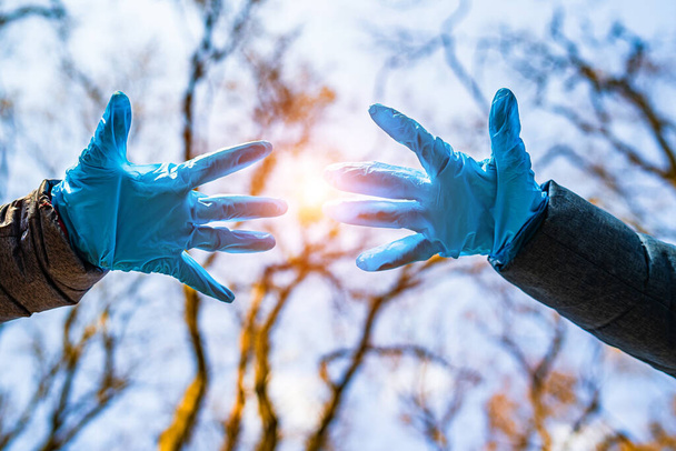 Hands in blue medical gloves on the street avoid the spread of coronavirus. Pandemic Covid-19. Stop coronavirus - Photo, image