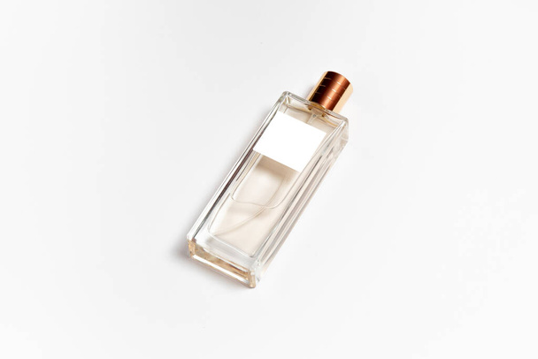 Przezroczysta makieta butelki perfum z pustą etykietą wyizolowaną na białym tle. Zdjęcie w wysokiej rozdzielczości. - Zdjęcie, obraz