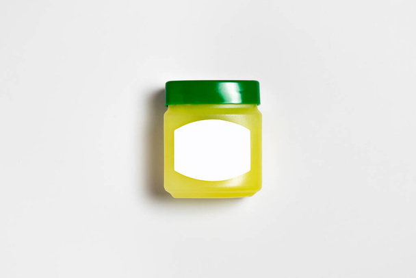 Pot carré en plastique avec une étiquette vierge pour les cosmétiques, crème, beurre, gommage, gel, cire. Modèle de maquette.Photo haute résolution.Vue supérieure.Gelée de pétrole
. - Photo, image
