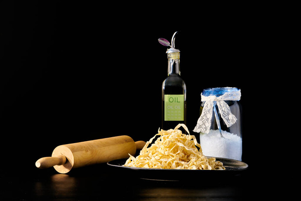 Tagliatelle italiano casero fresco con rodillo de madera, aceite de oliva y sal
 - Foto, Imagen