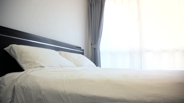 4K, otel odasında beyaz çarşaflı çift kişilik bir yatak. - Video, Çekim