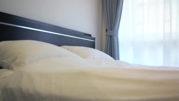 4K, Grappig meisje springen op een tweepersoonsbed met witte lakens in een hotelkamer -Dan - Video