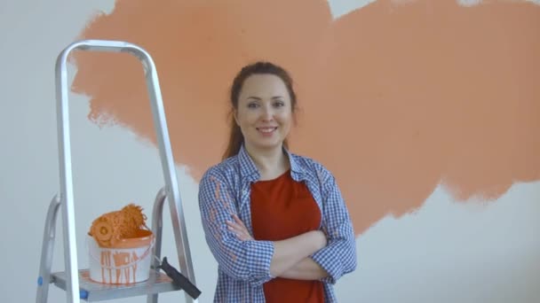 Concept de style de vie Singleton. Jeune femme heureuse peint ses murs en orange avec un rouleau - Séquence, vidéo