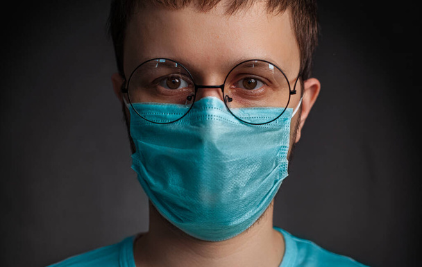 Portrait of a young doctor or surgeon in a mask who looks confident. Concept: doctor, patient care, health and Wellness in hospitals or private clinics - Photo, Image