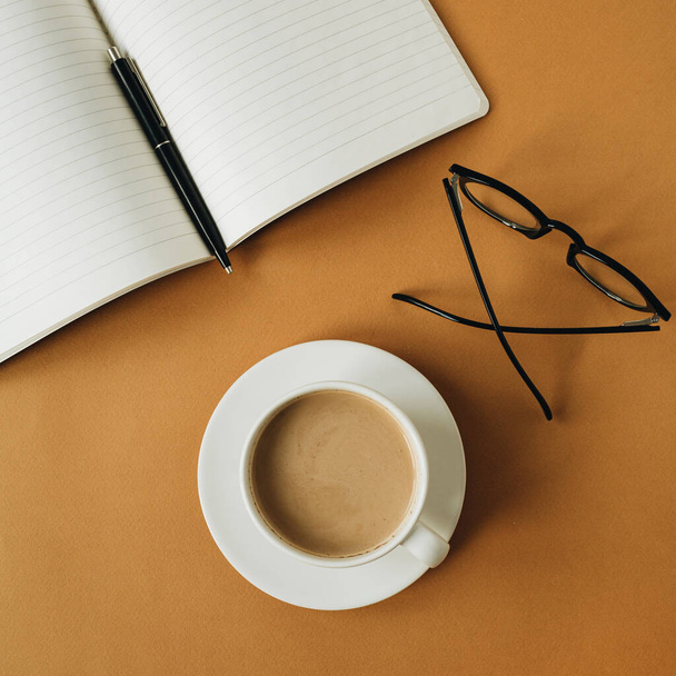 Moderno espaço de trabalho de escritório em casa com notebook, xícara de café, óculos no fundo de gengibre. Trabalho, conceito de negócio
. - Foto, Imagem