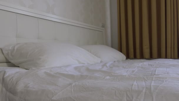 4K, otel odasında beyaz çarşaflı çift kişilik bir yatak. - Video, Çekim