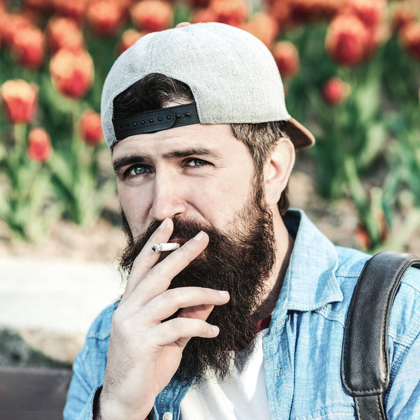 Bearded hipster smoking cigarette outdoors. Man thinking about something. Bearded worker has a break time. Smoking habit or addiction. Smoking addict or smoker. Hipster enjoy smoking break outdoors. - Photo, Image