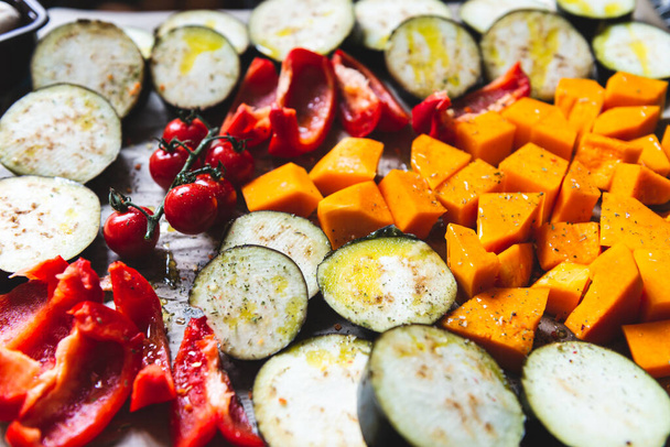 Zdrowa kolacja Detox z różnych warzyw, takich jak bakłażan, czerwony pieprz, pomidory wiśniowe, dynia. Kawałki surowych warzyw przygotowane do prażenia, prosty rodzinny posiłek - Zdjęcie, obraz
