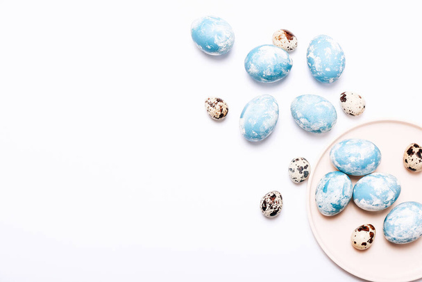 Stylish eggs with ombre blue marble stone effect with quail eggs on white background - Photo, image