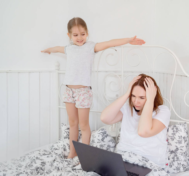 little girl interferes to work mom at home. - Photo, Image