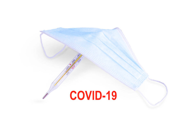 Napis Covid 19, maska z termometrem wyizolowanym na białym tle, zaszyty wirus covid-19, leczenie kliniczne, tło medyczne - Zdjęcie, obraz