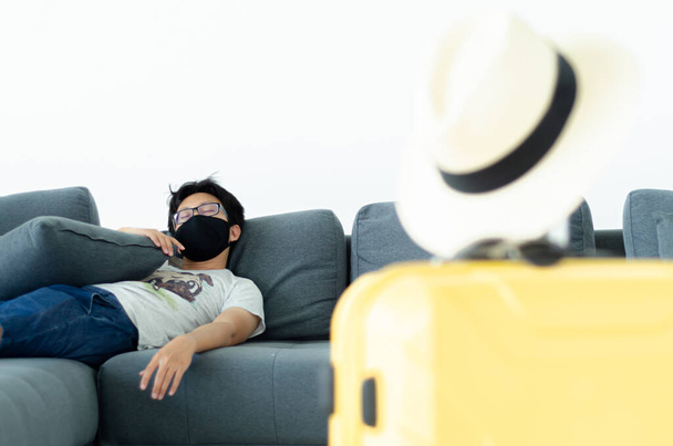 Asian Men Wearing Glasses Wearing a black mask Sleeping on the gray sofa in his room.A sick man is sleeping.On the gray sofa someone was resting. - Фото, изображение