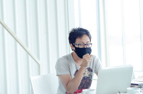 Asian Men Wearing Glasses Wearing a black mask Is working.A sick man sitting at work.In the white office there was a man in there. - Photo, Image