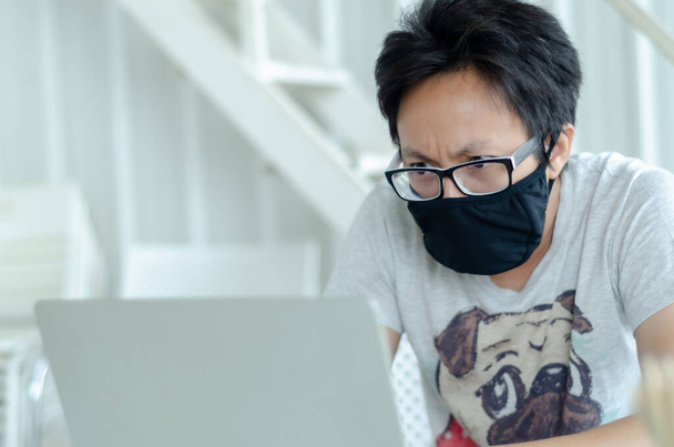 Asijští muži s brýlemi Nošení černé masky funguje. Nemocný muž sedí v práci.V bílé kanceláři tam byl muž. - Fotografie, Obrázek
