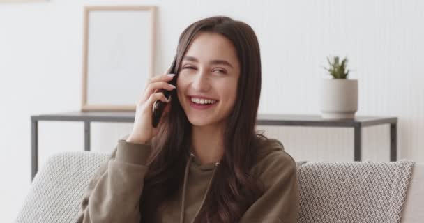 Positive millennial girl talking on cellphone at home - Felvétel, videó