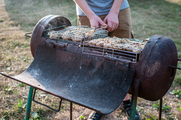 приготування сирого м'яса в сітці на грилі барбекю
 - Фото, зображення