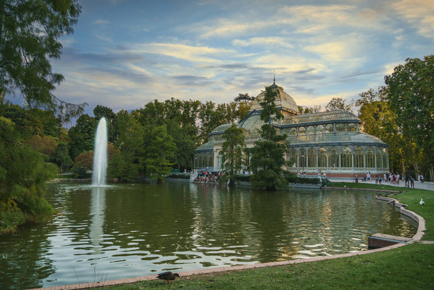 Palacio Cristal en el Parque del Retiro de Madrid con el lago al atardecer
 - Foto, Imagen
