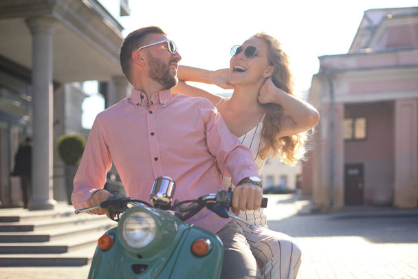 Young couple in love riding a motorbike. Riders enjoying themselves on trip. Adventure and vacations concept - Foto, Imagen
