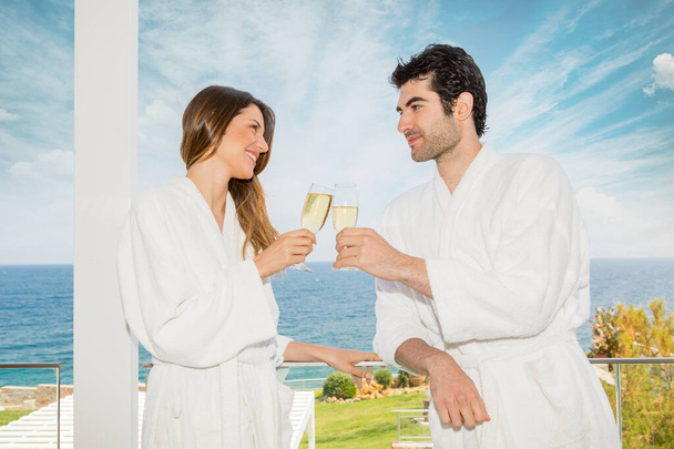 Young couple in bathrobe relaxing, drinking champagne - Foto, immagini