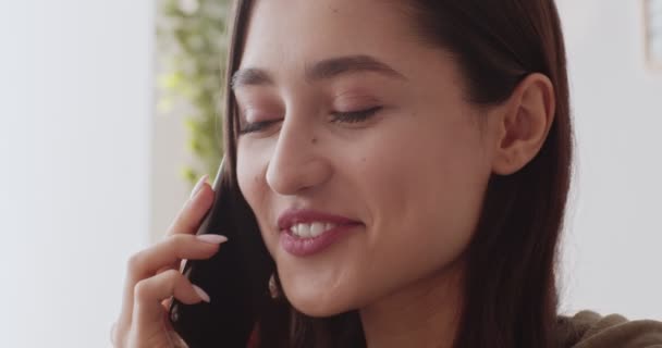 Playful girl talking on cellphone, flirting with boyfriend at home - Felvétel, videó
