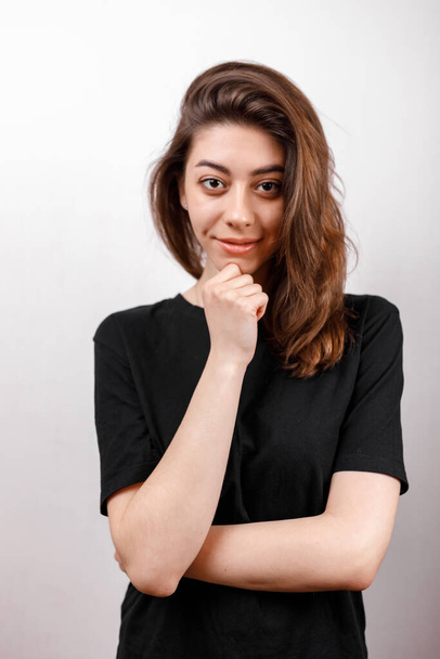 young brunette woman in a black shirt on a white background. emotions. isolate - Foto, Bild