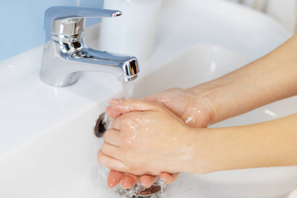 Soap in the hands of a girl. Hand washing - Φωτογραφία, εικόνα