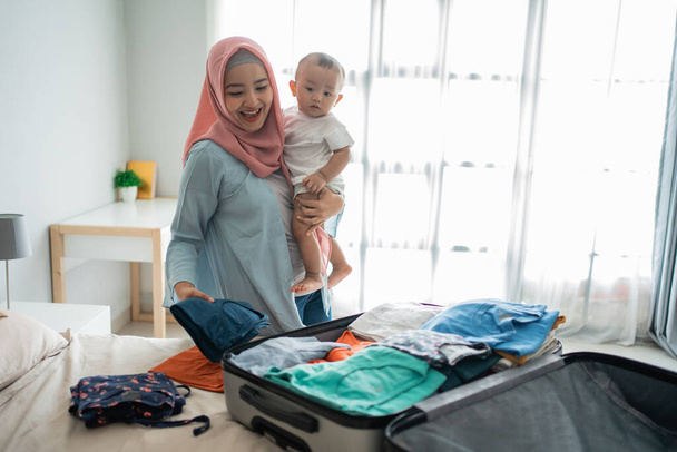 Muslim Asian mothers carry their children while preparing clothes - Valokuva, kuva