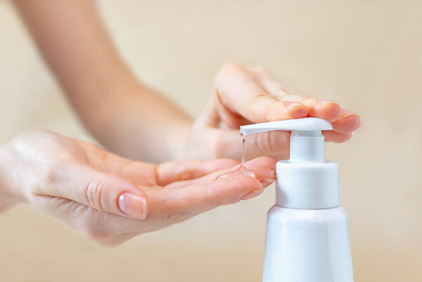 A female press on a bottle with antibacterial gel to clean and wash hands of bacteria and virus close-up. The concept of protection and prophylaxis against coronavirus disease. - Foto, immagini