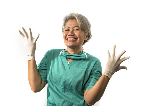 mature attractive and happy medicine doctor woman or hospital nurse in medical scrubs in face mask playful showing hands in latex gloves confident and cheerful in healthcare concept - Photo, Image