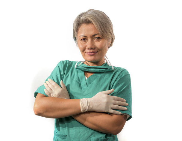 mature attractive and happy medicine doctor woman or experienced hospital nurse in medical scrubs in face mask with hands in latex gloves confident and cheerful - Valokuva, kuva